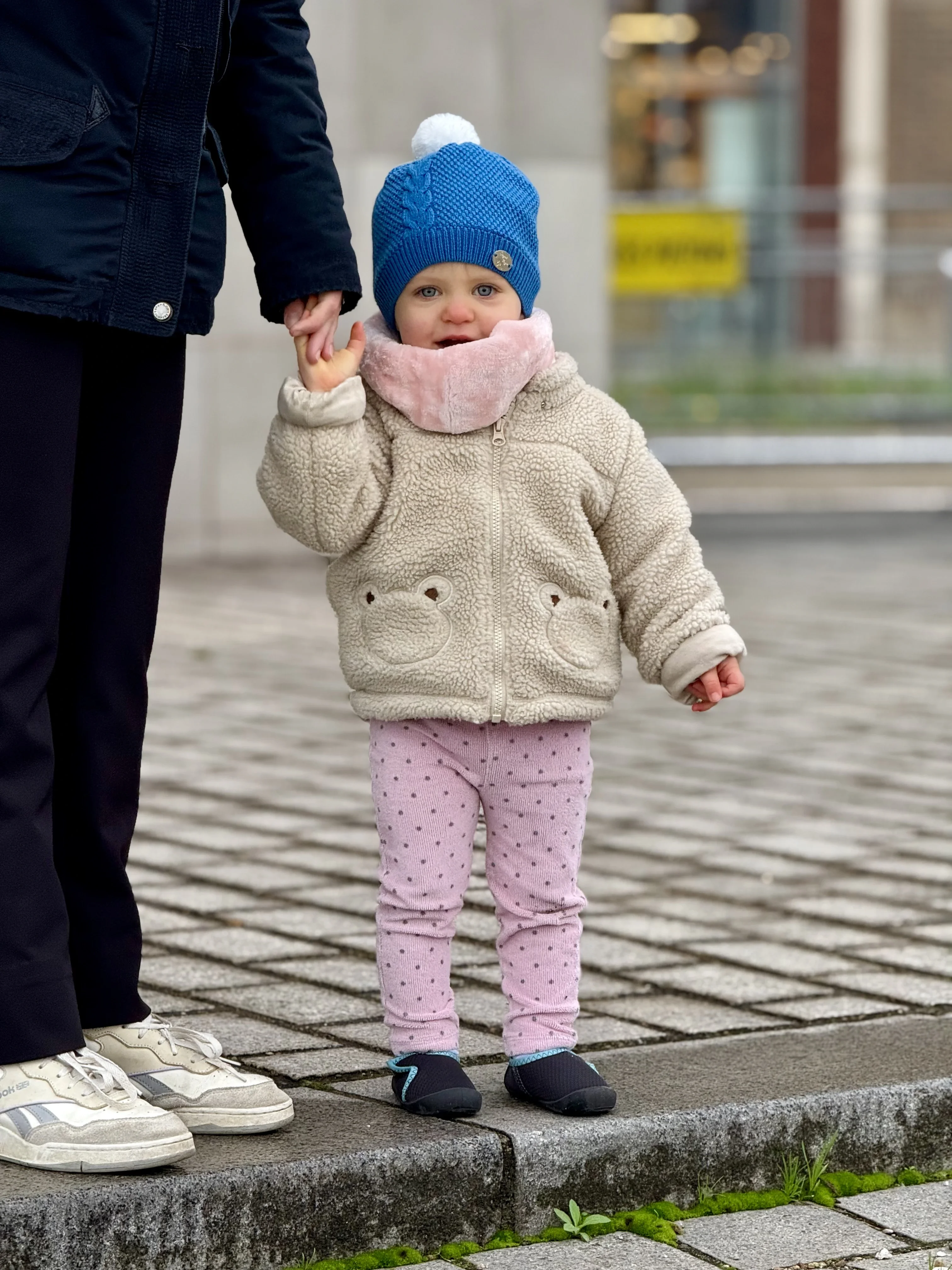 Ana Hope faisant ses premiers pas en tenant la main d'un adulte